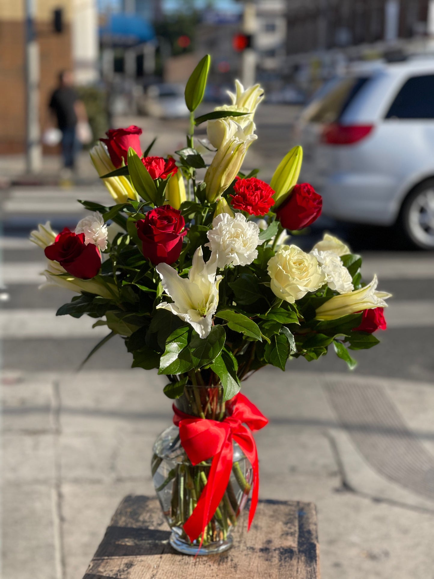 Combination of Red roses and white lilies & carnation in Glass vase image 0