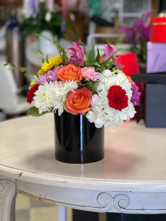 Mix flowers in a cylinder glass image 0